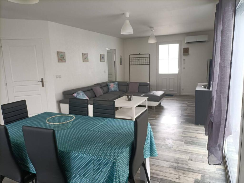 a living room with a couch and a table at Maison de vacances récente in La Bétaudière