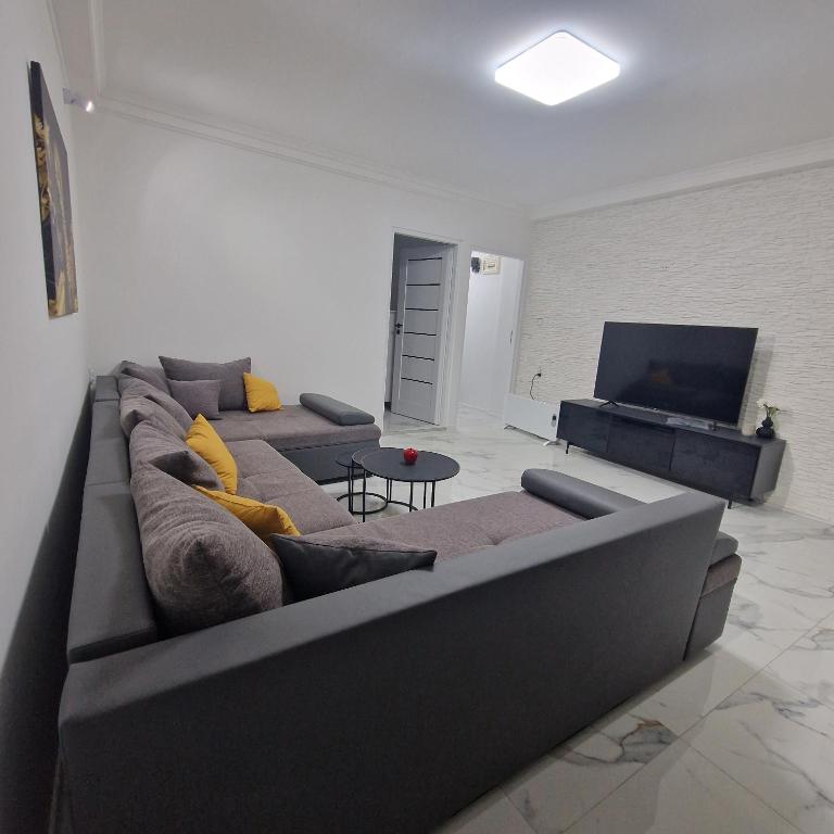 a living room with a couch and a flat screen tv at APARTMAN MAYA 2 in Buzin