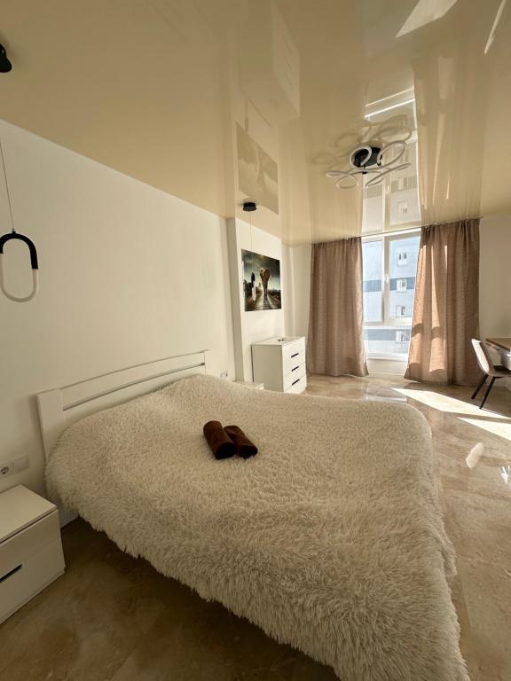 1 dormitorio con 1 cama con sombrero marrón en Апартаменти Білогірська НОВА, en Ternopilʼ