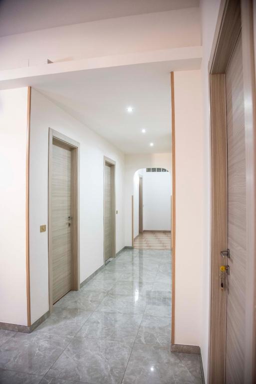 an empty hallway with white walls and tile floors at Blu Mare Lampedusa Bed And Breakfast in Lampedusa