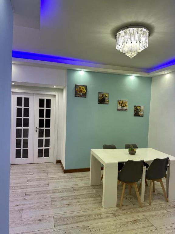 a dining room with a table and chairs and a chandelier at Lovely house in Luanda Centre with treadmill in Luanda