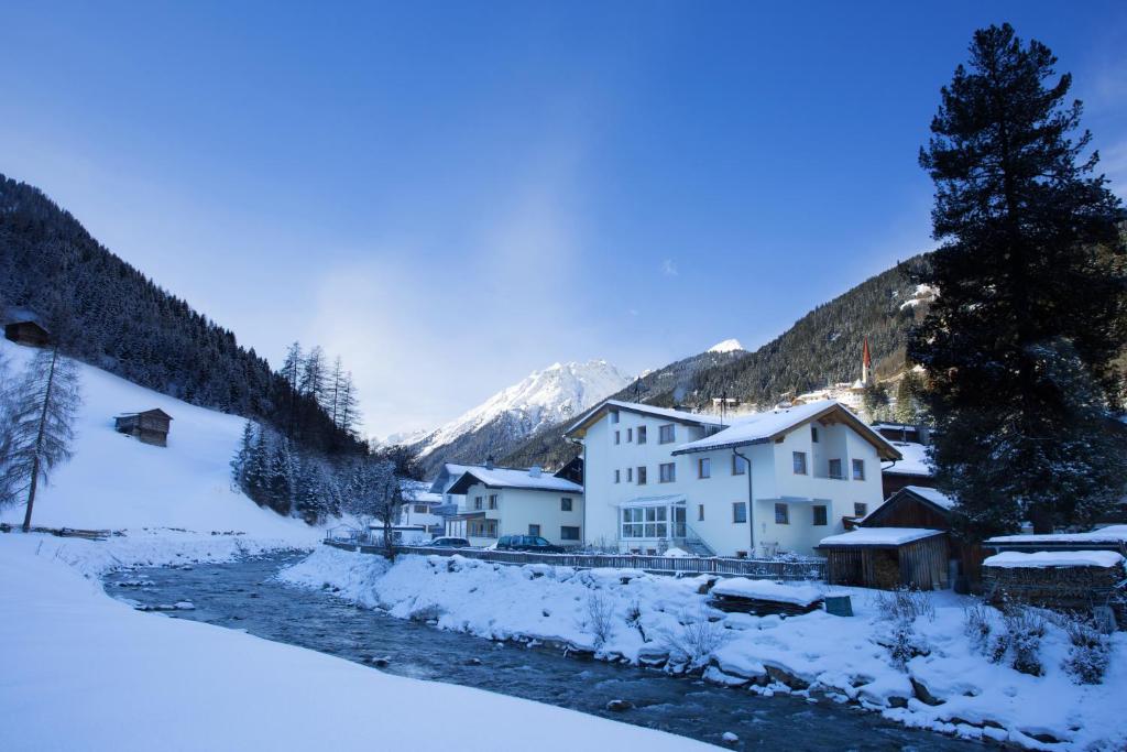 un pueblo en las montañas cubierto de nieve en Hotel Garni DIAS, en Kappl