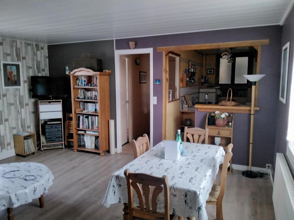 una sala da pranzo con tavolo e sedie in una stanza di Appartement centre ville classé unesco a Le Havre