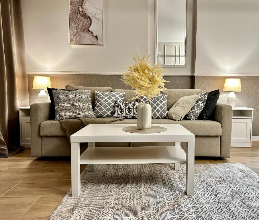 a living room with a couch and a coffee table at Apartamenty Kielce- CAPPUCCINO APARTAMENT, faktura, parking, centrum in Kielce