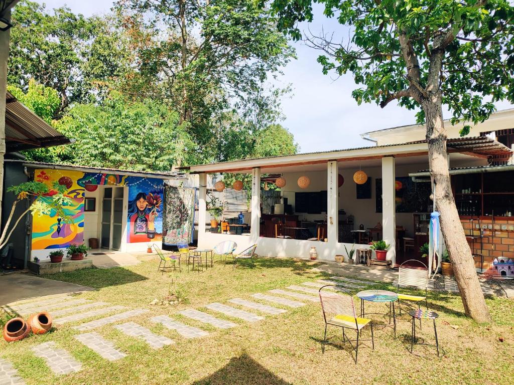 une maison avec des chaises et un arbre dans la cour dans l'établissement ALMÁZYGO Bed & Breakfast, à Tarapoto