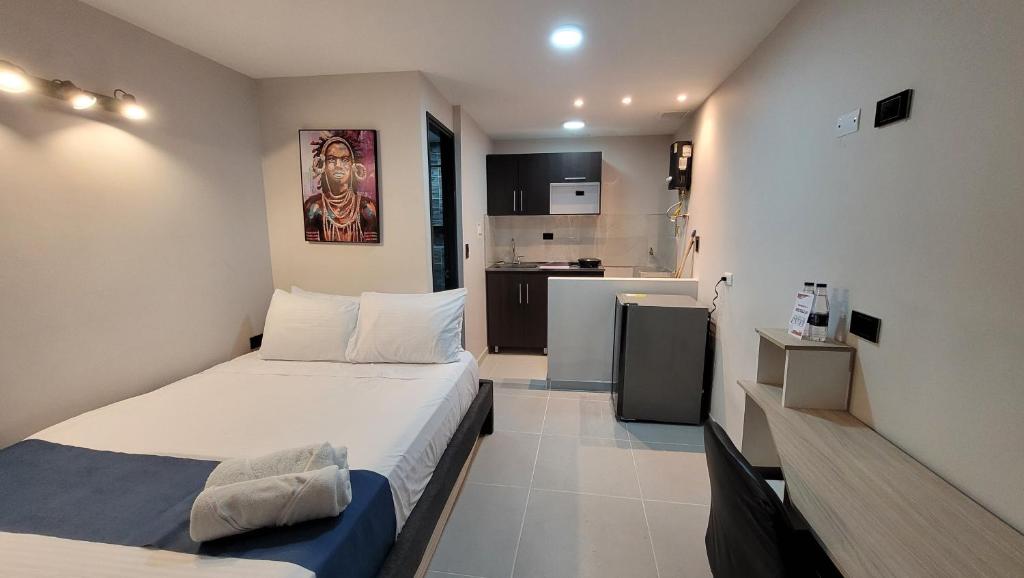 małą sypialnię z łóżkiem i kuchnią w obiekcie ANDALIVING CAMPO VALDÉS Estudio w mieście Medellín