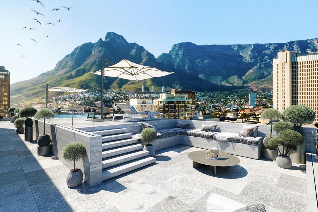 a rooftop patio with a view of a city at Luxury Mountain View Aparthotel at The Tokyo- 12th Floor No Loadshedding in Cape Town