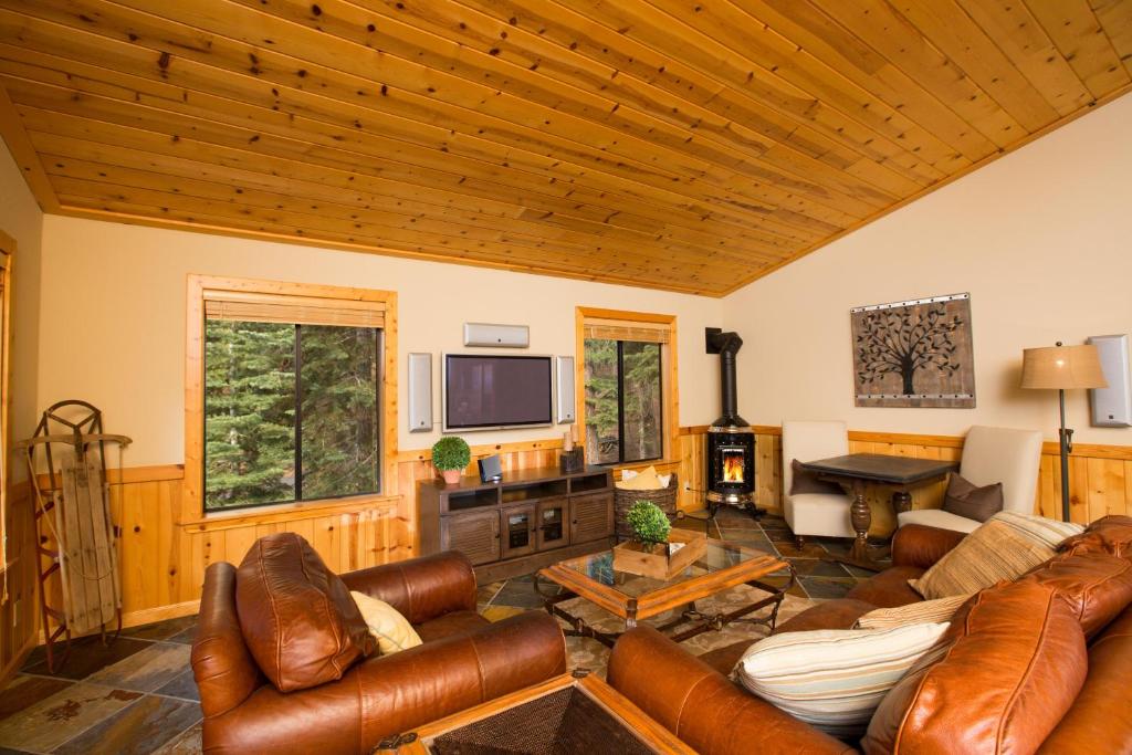 a living room with leather furniture and a flat screen tv at St Bernard at Tahoe Donner Remodeled 3BR - Private Hot Tub and Gym and Pool Access in Truckee