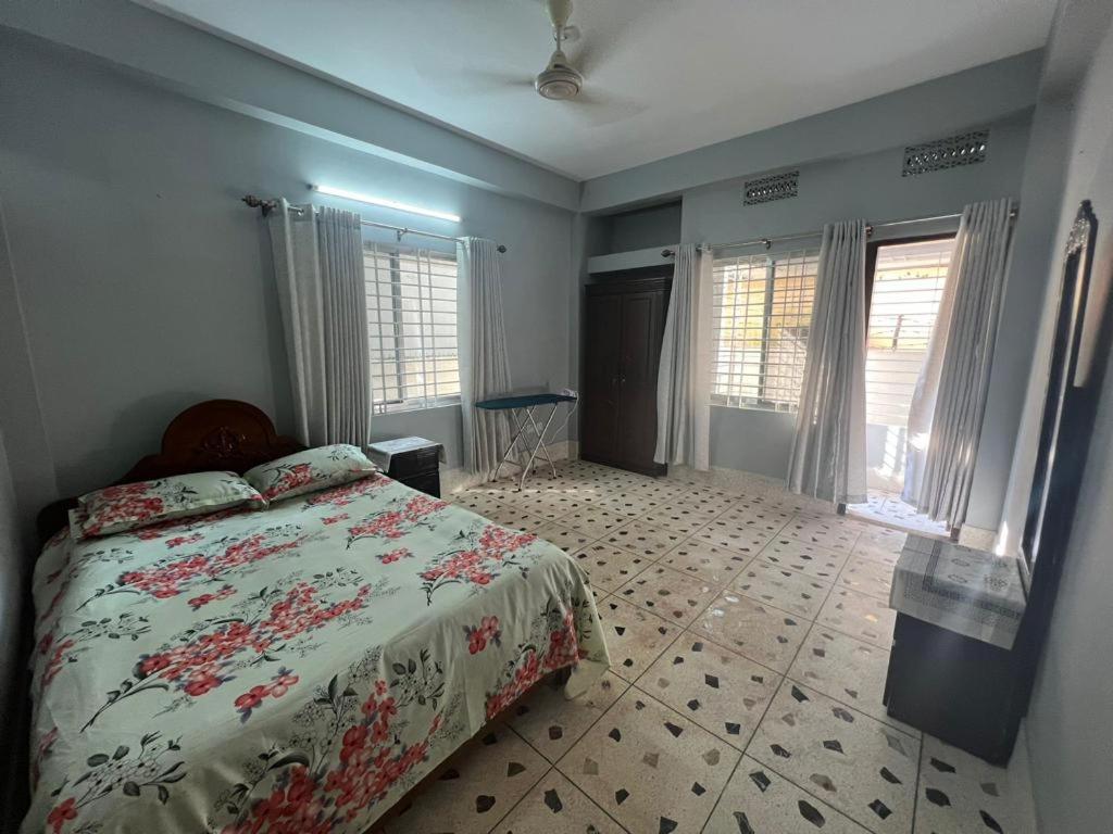 1 dormitorio con 1 cama y algunas ventanas en Alom Manzil - 4 Bedroom Family Home en Sylhet