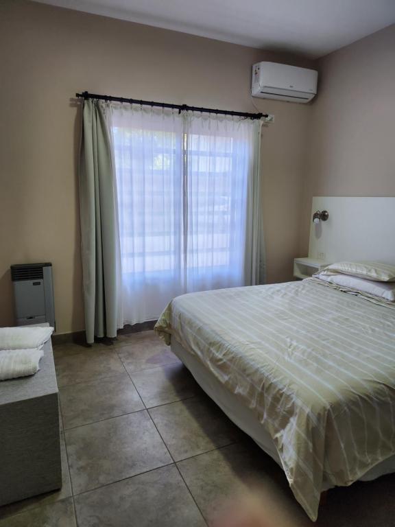 a bedroom with a large bed and a window at Real .Departamento in Luján