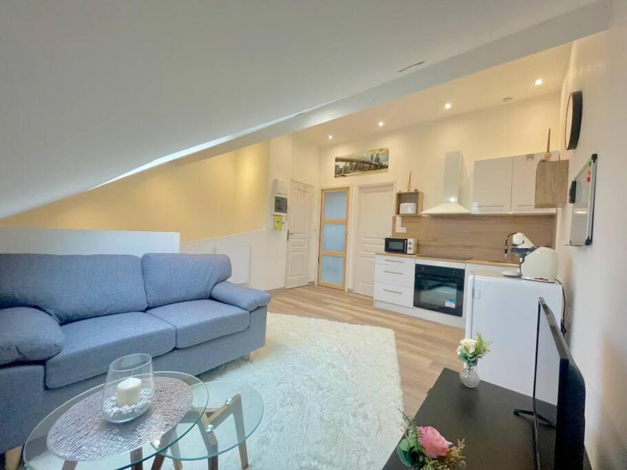 un salon avec un canapé bleu et une table dans l'établissement Chaleureux et convivial, à Saint-Quentin