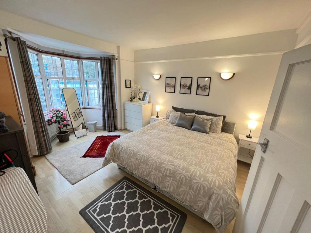 ein Schlafzimmer mit einem Bett und einem großen Fenster in der Unterkunft The Rumah at Hyde Park in London