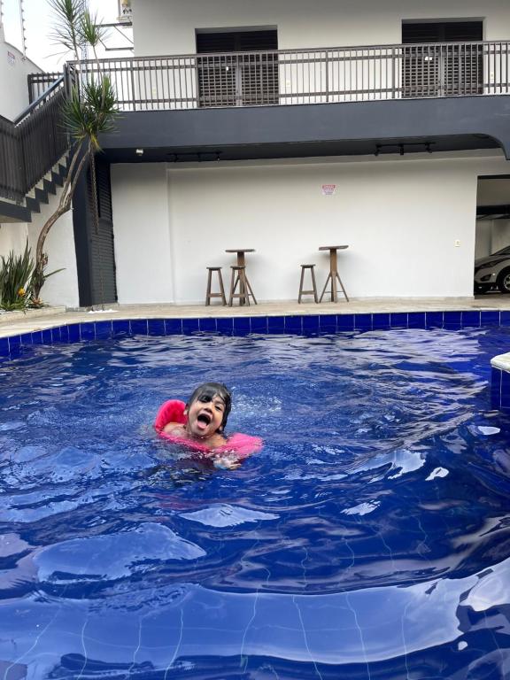 um rapaz a nadar numa piscina em Acomodações do Tio Will - 2 no Guarujá