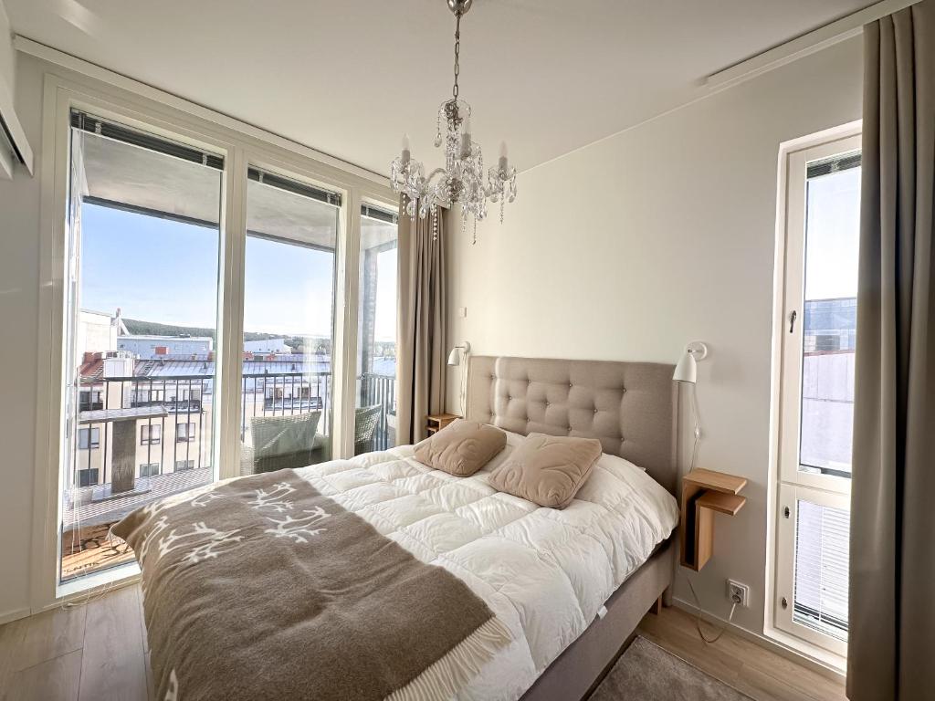 a bedroom with a large bed and large windows at Hostit Arctic Apartments in Rovaniemi