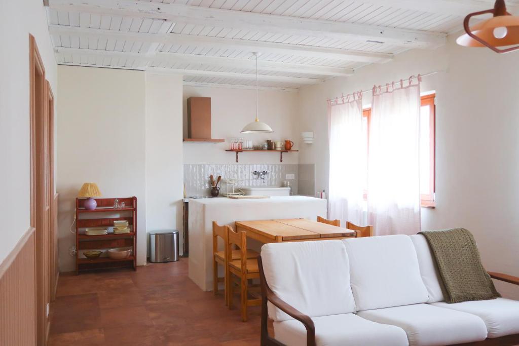 a living room with a white couch and a kitchen at Appartement cosy sur la route des vins d'Alsace in Dambach-la-Ville