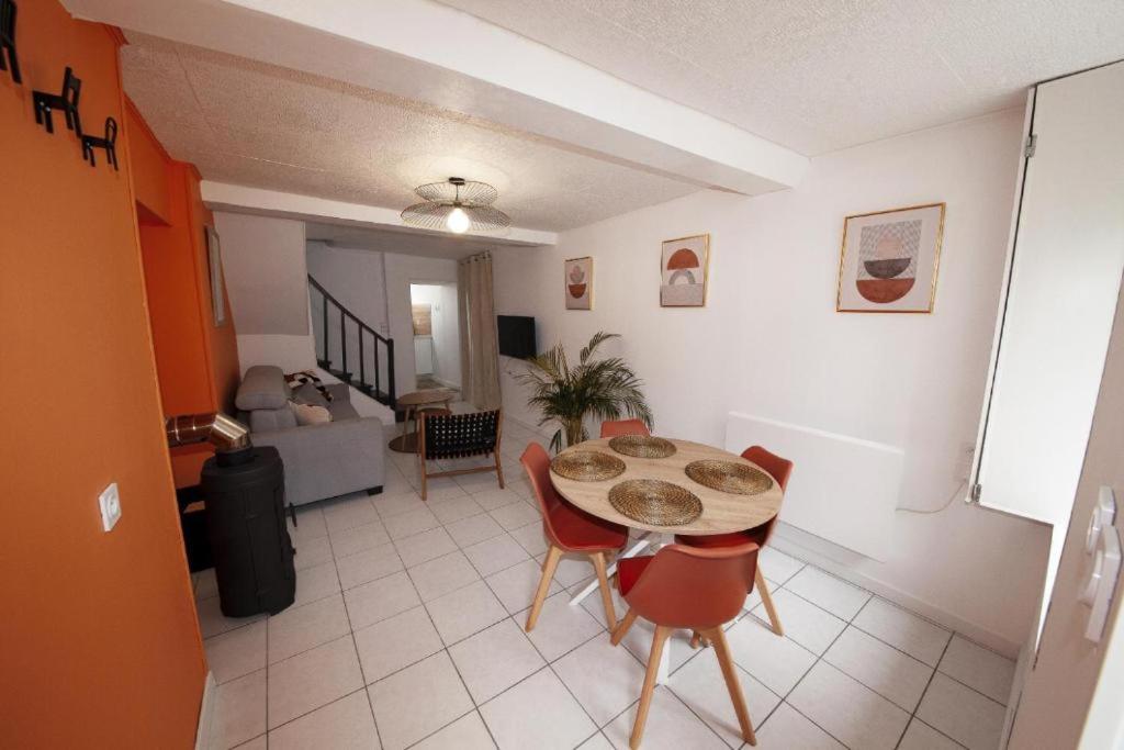 a room with a table and chairs and a living room at Gîte La Foresienne in Putanges-le-Lac