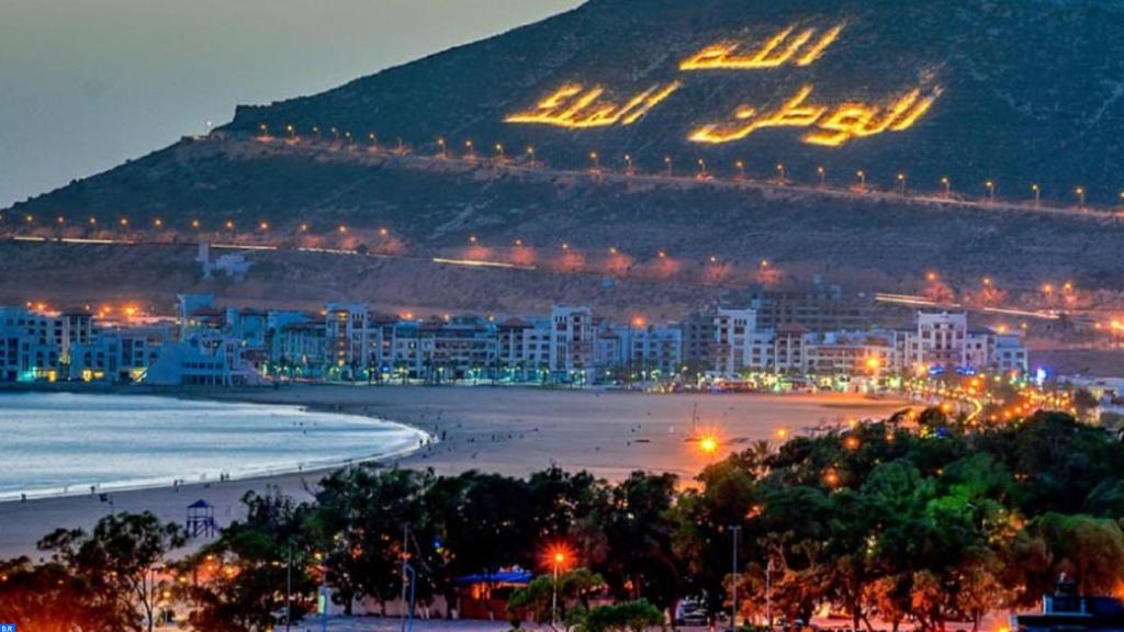 Blick auf den Strand in der Nacht mit einer Stadt in der Unterkunft Villa Charaf in Agadir