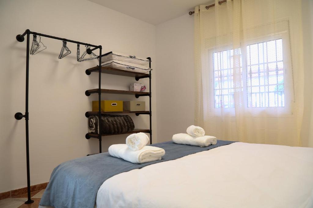a bedroom with a bed with towels on it at Casa Centro Fuengirola in Fuengirola