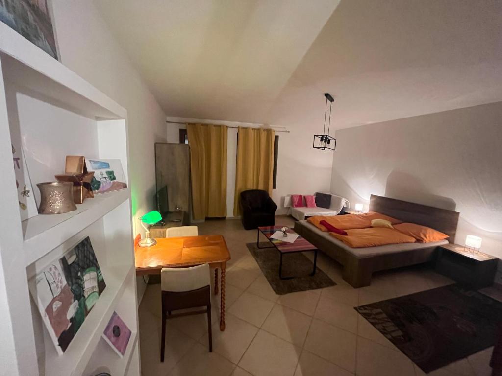 uma sala de estar com uma cama e uma mesa em Monelly Apartman em Komárno