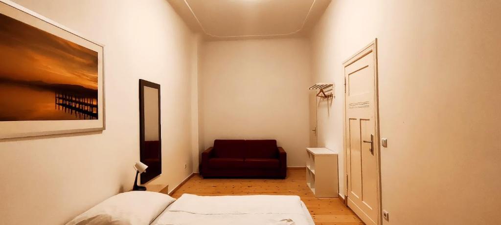 a small room with a bed and a red chair at Thomas Apartments in Berlin