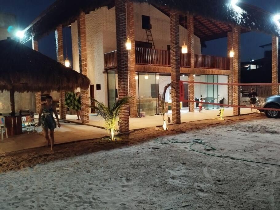 een vrouw die 's nachts voor een gebouw loopt bij Casa Bulegon in Itapipoca