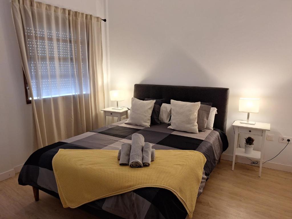 1 dormitorio con 1 cama con 2 toallas en habitacion con baño privado en un piso con familia en Santa Cruz de la Palma