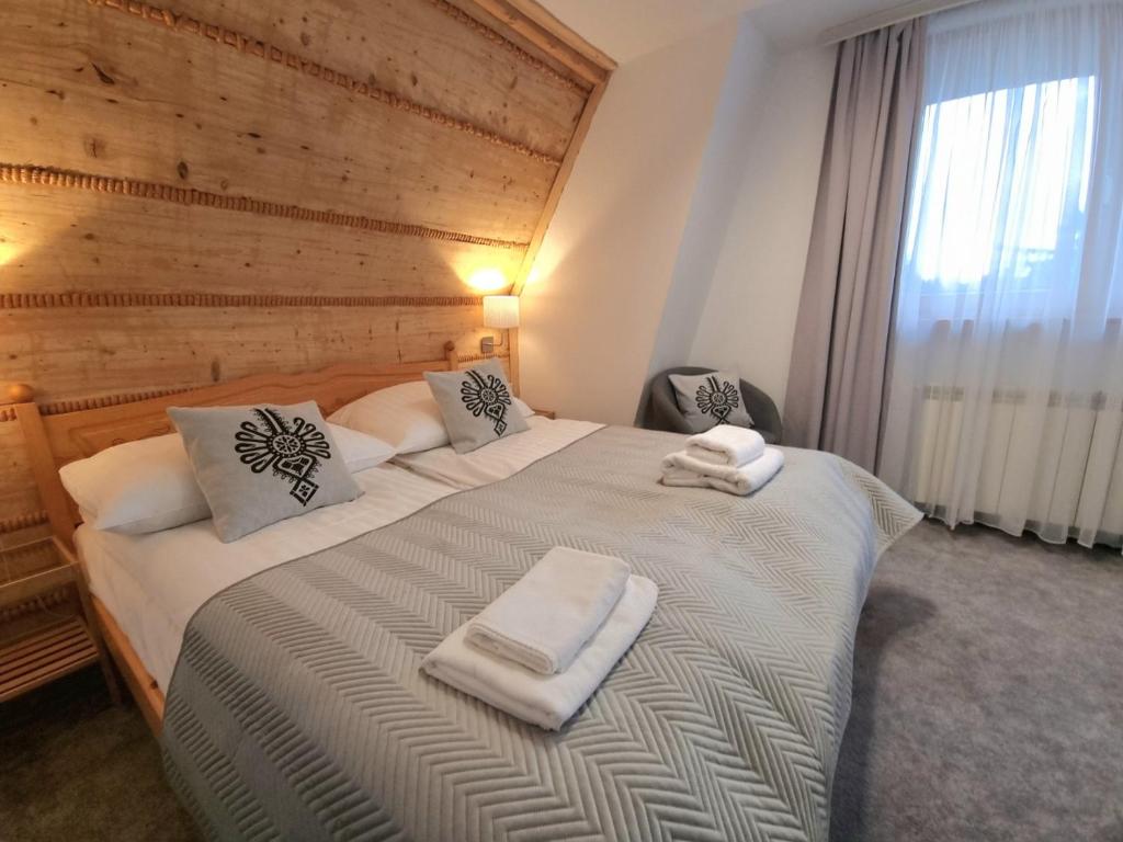 1 dormitorio con 1 cama grande y toallas. en Willa Antałówka, en Zakopane
