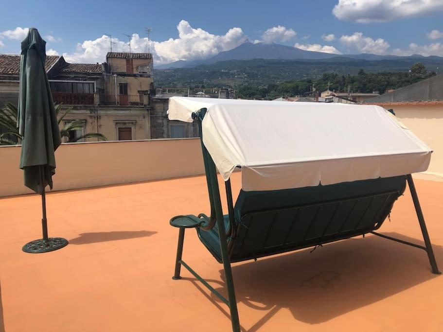 een bed op het dak met een paraplu bij Il Belvedere di Nonna Vincenza - Taormina side in Piedimonte Etneo