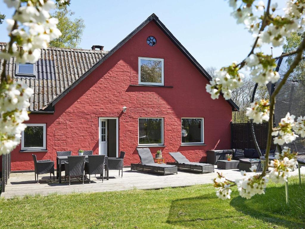 ein rotes Haus mit einem Tisch und Stühlen davor in der Unterkunft Holiday home Nexø XLI in Neksø