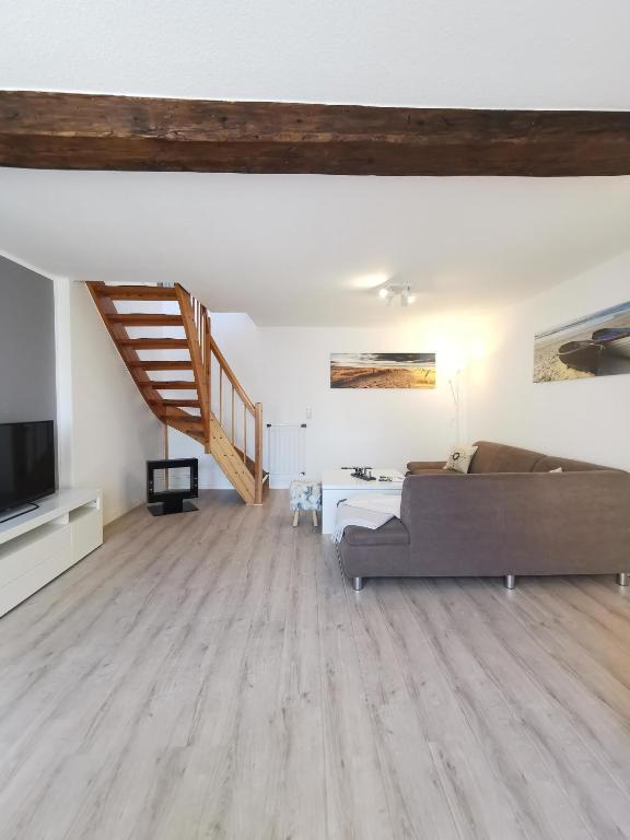 a living room with a couch and a staircase at Fewo Wolgast Usedom Ostsee in Wolgast