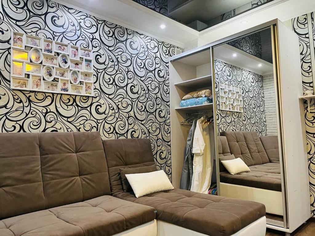 vestidor con sofá y espejo en Апартаменты 2 ком в ЖК Альтаир возле гипер Дина, en Aktobe