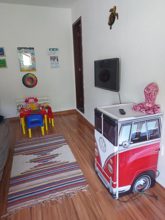 ein Wohnzimmer mit einem Spielzeugvan auf dem Boden in der Unterkunft Aconchego do Bem-te-vi 2 qtos 60m2 Praia Grande in Arraial do Cabo
