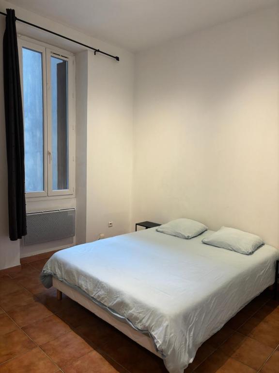 a white bed in a room with a window at T2 vue mer CATALANS - NETFLIX - VELODROME in Marseille