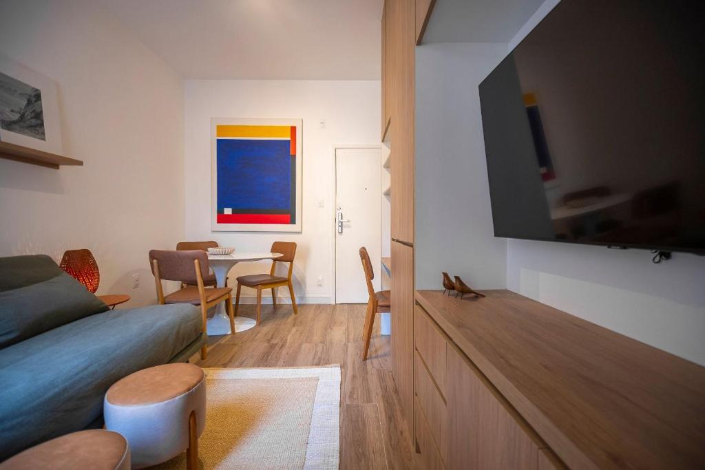 a living room with a couch and a table with chairs at Conforto e praticidade na Gávea -por Casapē in Rio de Janeiro