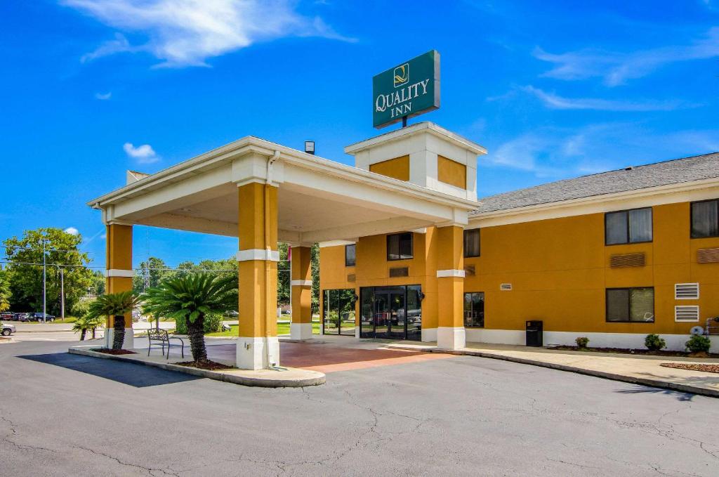 a yellow hotel with a sign on top of it at Quality Inn Saraland in Saraland