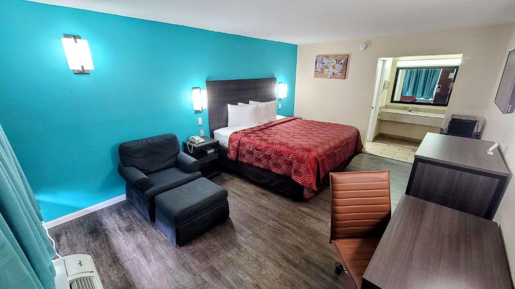 une chambre d'hôtel avec un lit et une chaise dans l'établissement Econo Lodge, à Kosciusko