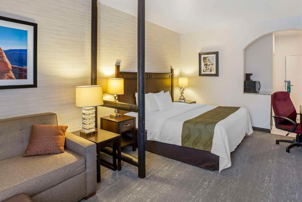 a hotel room with a bed and a couch at Quality Suites Moab near Arches National Park in Moab