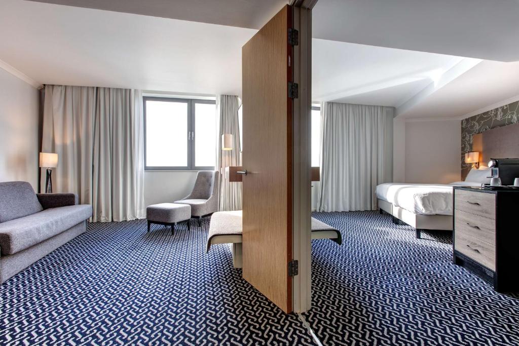 a hotel room with two beds and a couch at Radisson Blu Waterfront Hotel, Jersey in Saint Helier Jersey