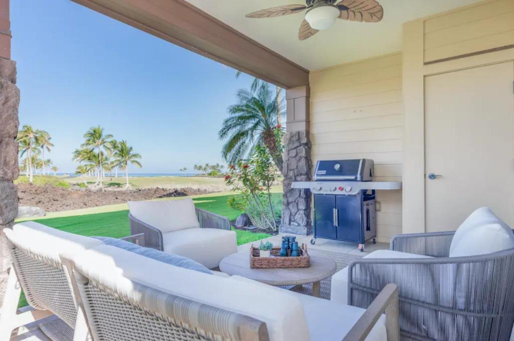 a patio with a couch and chairs and a fireplace at Hali'i Kai - Waikoloa in Waikoloa