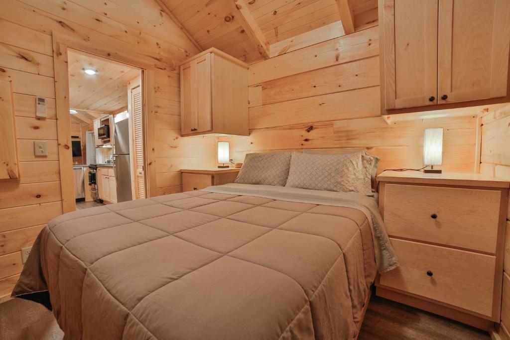 a bedroom with a bed in a wooden cabin at Stefan Cabin Nature-nested Tiny Home Hot Tub in Chattanooga