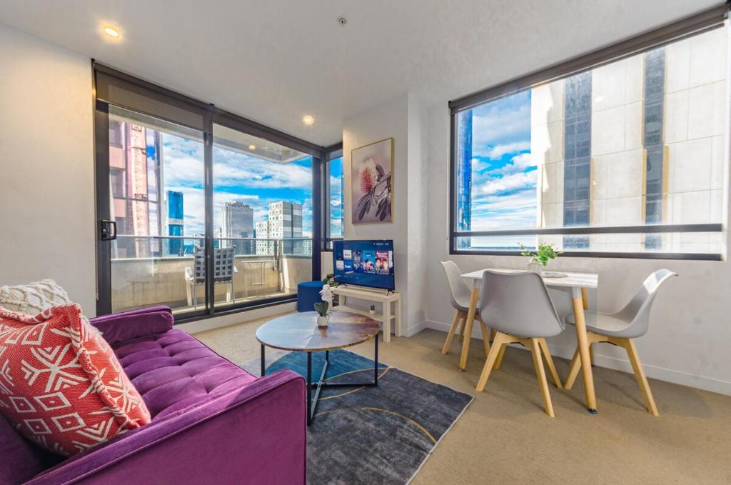 a living room with a purple couch and a table at High Level On 42th Floor 2br 1ba Balcony in Melbourne