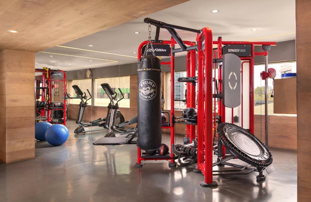 A functional-training gym with punching bags, cardio machines, and open floor space.