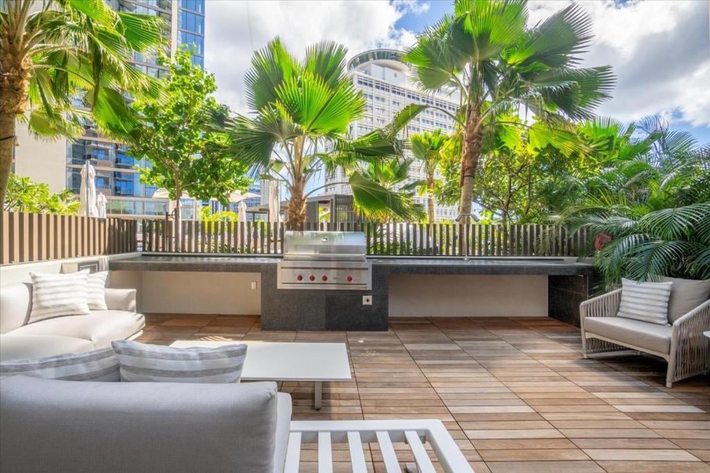 d'une terrasse avec un barbecue et des palmiers. dans l'établissement Sky Ala Moana 2908 condo, à Honolulu