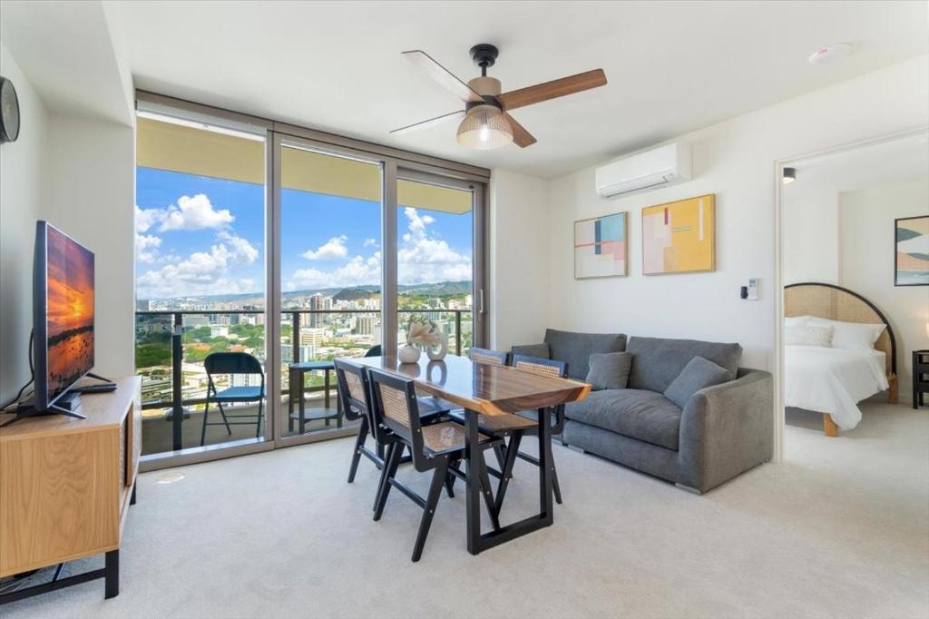 a living room with a table and a couch and a television at Sky Ala Moana 2908 condo in Honolulu