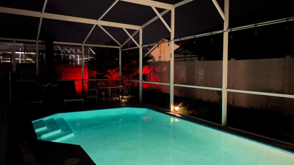 a swimming pool in a building at night at Renovated Entire House Heated Pool Close 2 Disney in Kissimmee