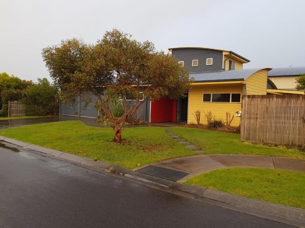 a house with a tree in the front yard at Flying Colours Free Wifi in Inverloch
