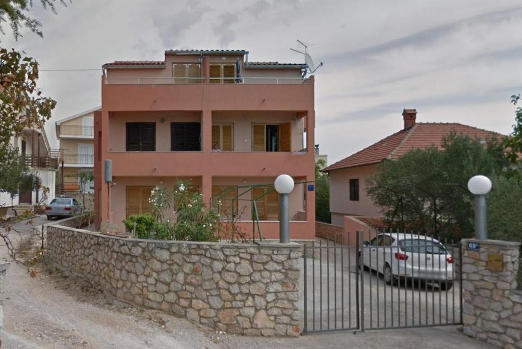 uma casa com uma cerca e uma parede de pedra em Apartments by the sea Pirovac, Sibenik - 21874 em Pirovac