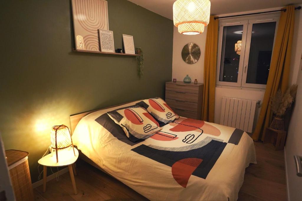 Un dormitorio con una cama con almohadas. en Appartement Cosy Beauvais en Beauvais