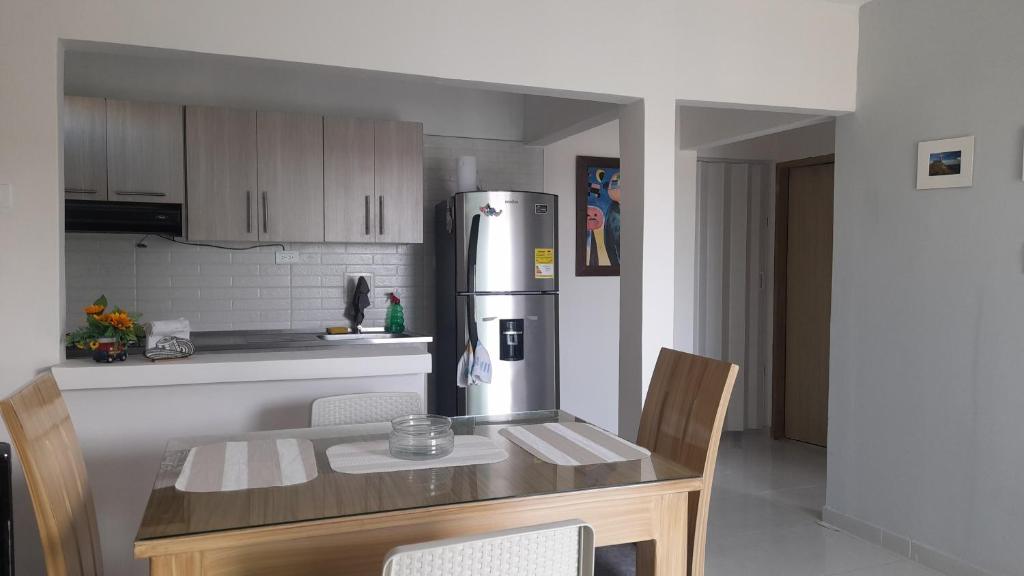a kitchen with a table and a stainless steel refrigerator at Acogedor apartamento Malala's in Sincelejo