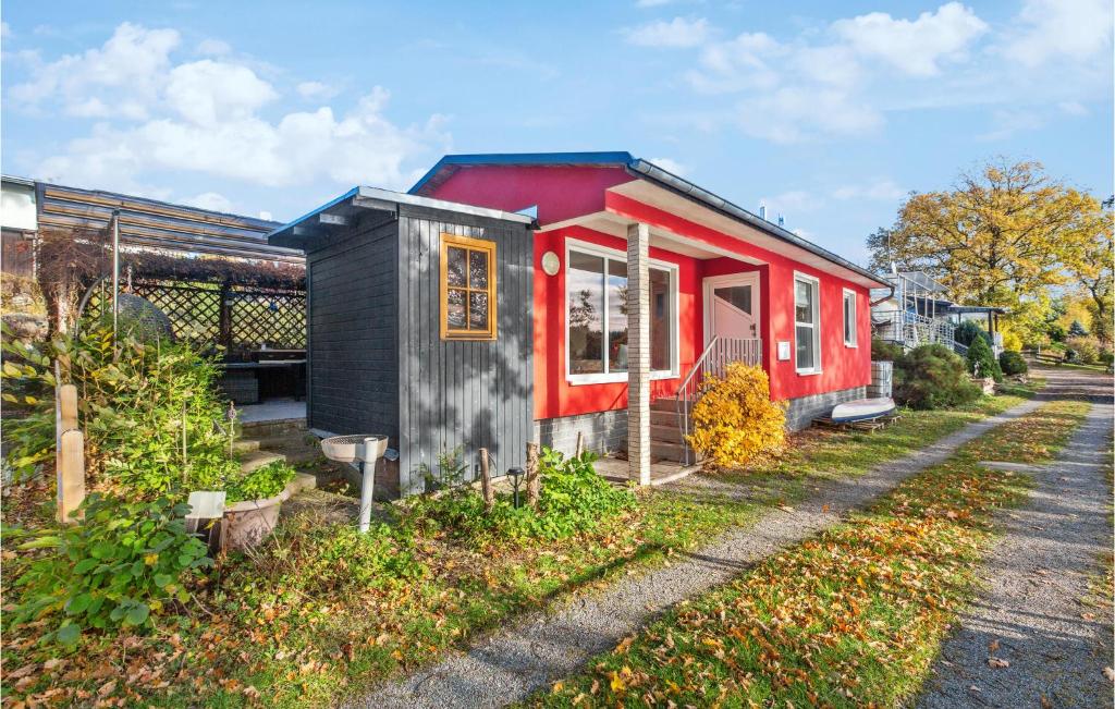 uma pequena casa vermelha e preta num quintal em Lovely Home In Zeulenroda-triebes With Sauna em Stelzendorf
